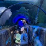 Dad and 2 girls in Ocean Tunnel at SEA LIFE Blackpool with ray swimming over them