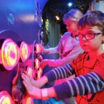 children pressing buttons in an aquarium