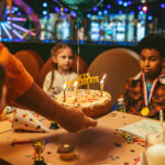 children sat at a table with a birthday cake in front of them