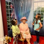 2 girls with wax model of Queen at Madame Tussauds